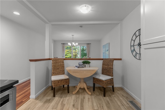 dining space with a chandelier and light hardwood / wood-style flooring