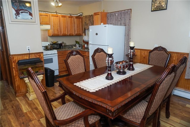 dining area featuring dark hardwood / wood-style flooring and a baseboard heating unit