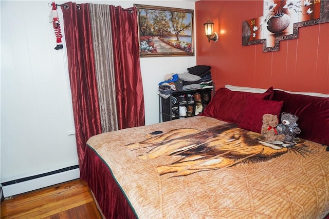 bedroom with a baseboard radiator and hardwood / wood-style floors