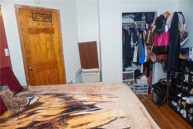 bedroom with dark wood-type flooring and a closet