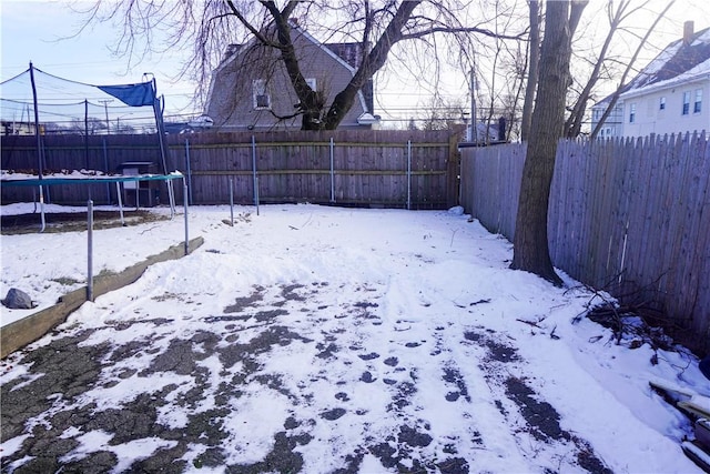 snowy yard featuring a trampoline