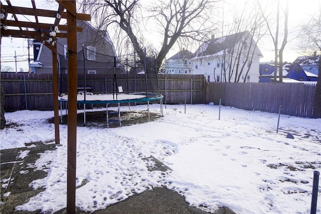 snowy yard featuring a trampoline