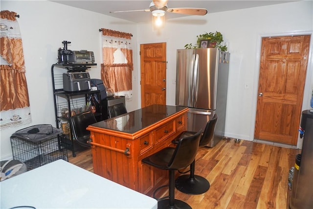 kitchen with hardwood / wood-style flooring, stainless steel refrigerator, and ceiling fan