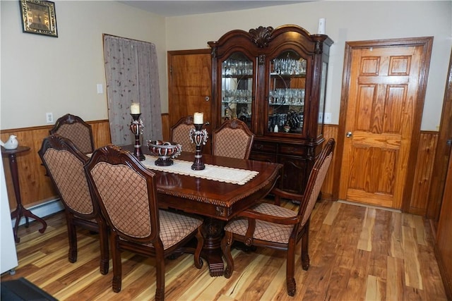 dining room with wood-type flooring and a baseboard heating unit