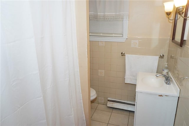 bathroom with toilet, tile walls, vanity, tile patterned flooring, and a baseboard heating unit