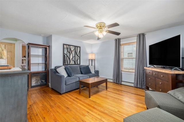 living room with light hardwood / wood-style floors, a textured ceiling, and ceiling fan