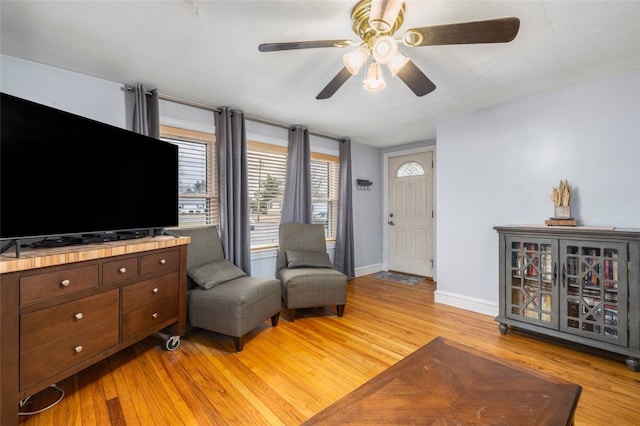 living room featuring ceiling fan and light hardwood / wood-style floors