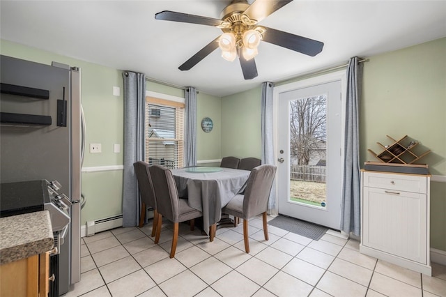 dining space with light tile patterned floors, plenty of natural light, a baseboard heating unit, and ceiling fan