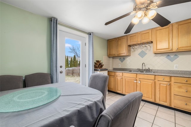 kitchen featuring sink, light tile patterned flooring, backsplash, and ceiling fan