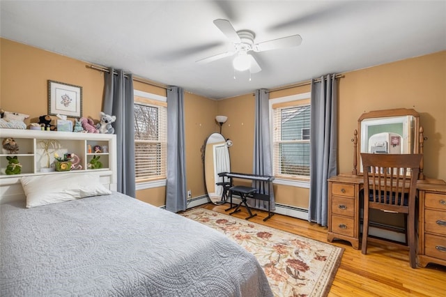 bedroom with ceiling fan, light hardwood / wood-style flooring, and a baseboard radiator