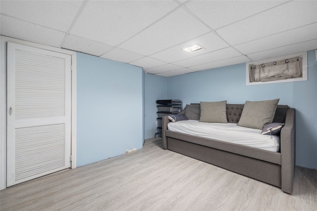 interior space featuring light hardwood / wood-style floors, a drop ceiling, and a closet