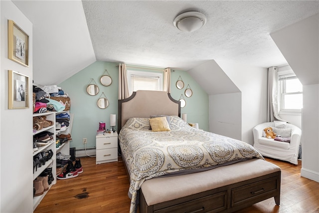 bedroom with multiple windows, hardwood / wood-style floors, and vaulted ceiling