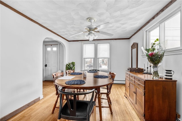 dining room with baseboard heating, light hardwood / wood-style flooring, ceiling fan, and ornamental molding