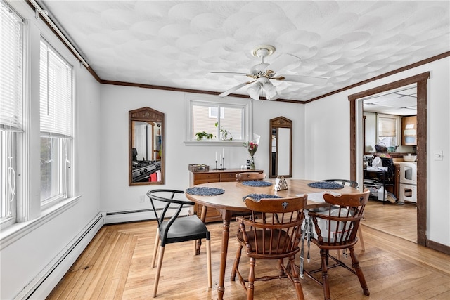 dining space featuring ceiling fan, light hardwood / wood-style flooring, ornamental molding, and baseboard heating