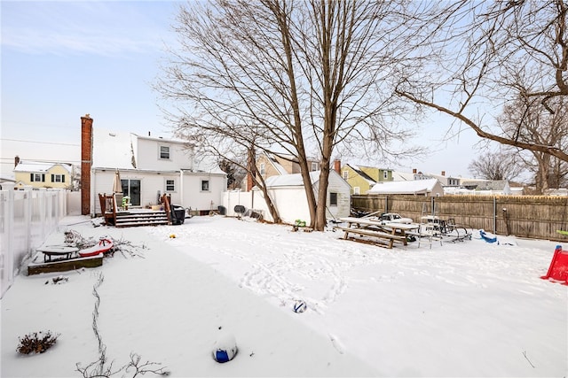 yard covered in snow featuring a deck and a shed