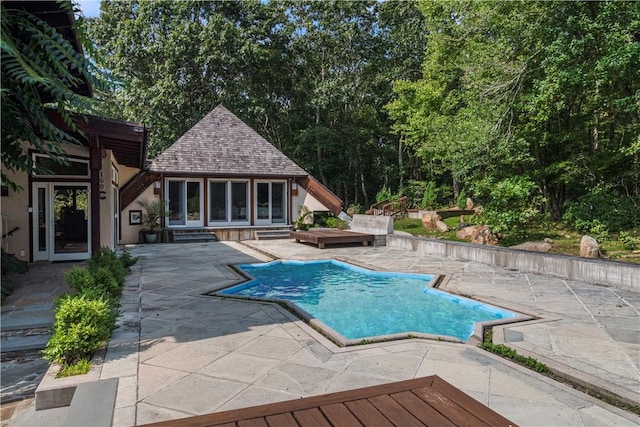 view of swimming pool with a patio and an outbuilding