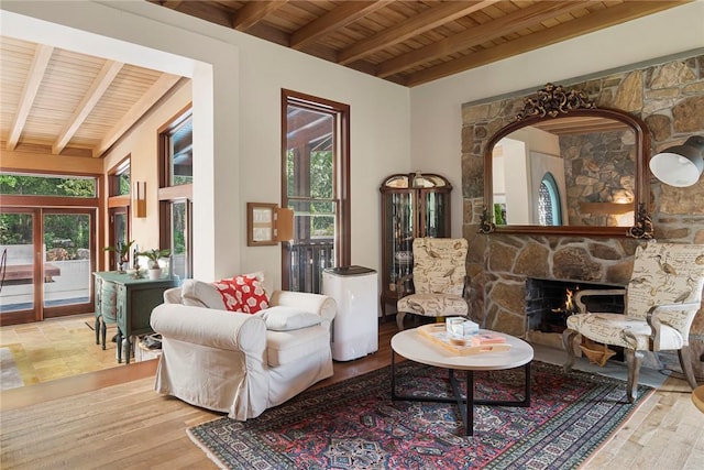 sitting room with beamed ceiling, light hardwood / wood-style flooring, wood ceiling, and a fireplace