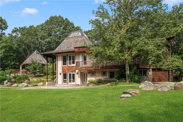 back of property featuring a deck and a lawn