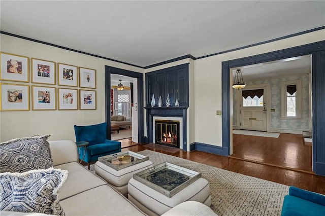 living room with dark wood-type flooring and ornamental molding