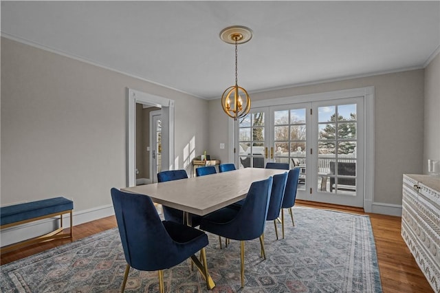 dining area with ornamental molding, wood-type flooring, and a chandelier