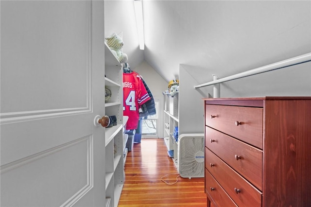 walk in closet with vaulted ceiling and light hardwood / wood-style flooring