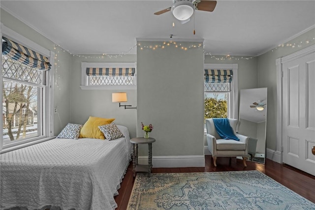 bedroom featuring multiple windows, dark hardwood / wood-style flooring, and ceiling fan