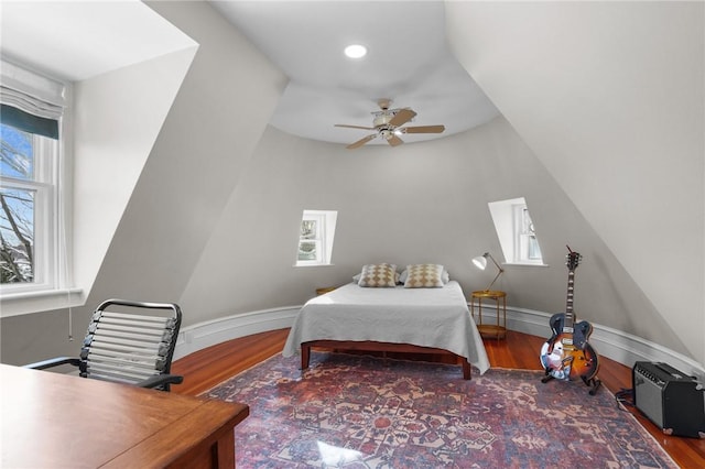 bedroom with multiple windows, wood-type flooring, and ceiling fan