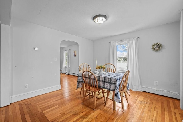 dining area featuring light wood-type flooring and a baseboard heating unit