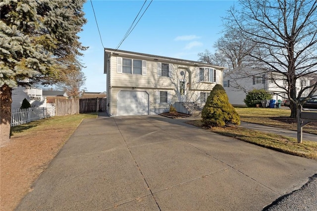 bi-level home with a garage and a front yard