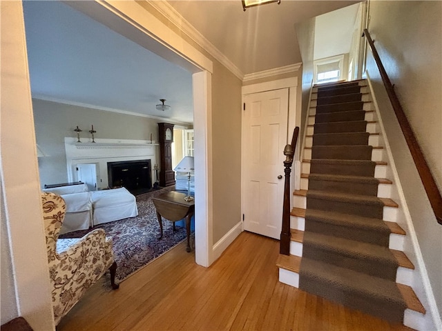 stairway featuring hardwood / wood-style flooring and ornamental molding