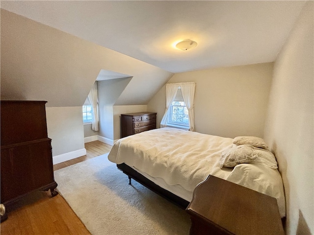 bedroom featuring vaulted ceiling and wood-type flooring