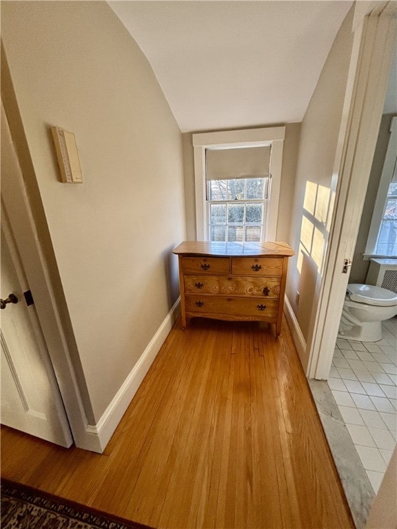 hallway featuring light hardwood / wood-style floors and lofted ceiling