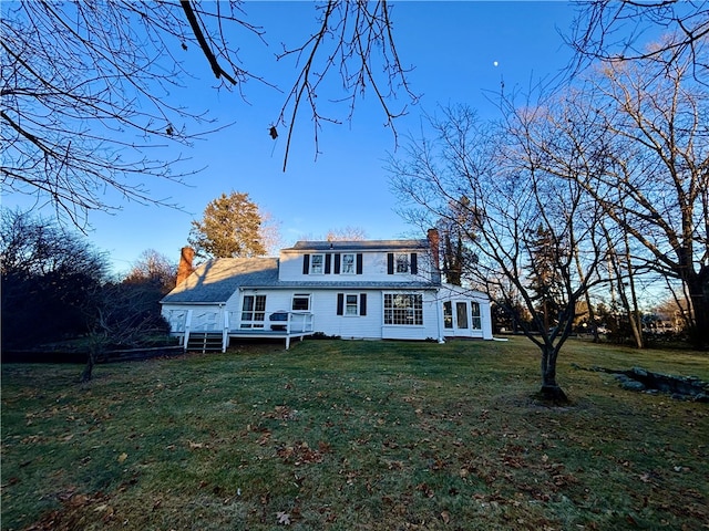 view of front of house with a deck and a front lawn