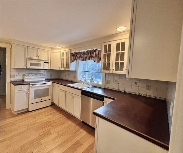 kitchen featuring sink, white cabinets, white appliances, and light hardwood / wood-style flooring