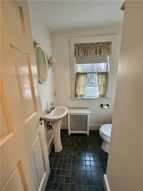 bathroom featuring toilet, radiator, and tile patterned flooring