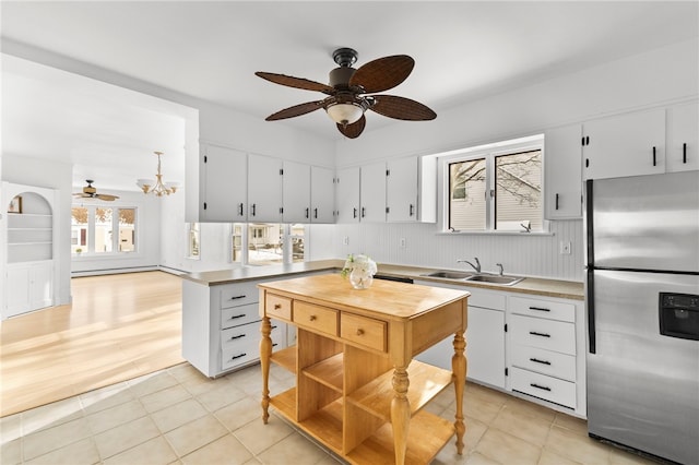 kitchen with sink, white cabinetry, light tile patterned floors, and stainless steel fridge with ice dispenser