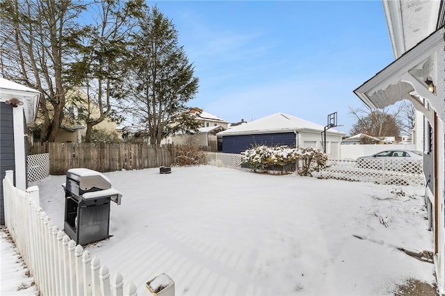 yard covered in snow featuring an outbuilding and a garage