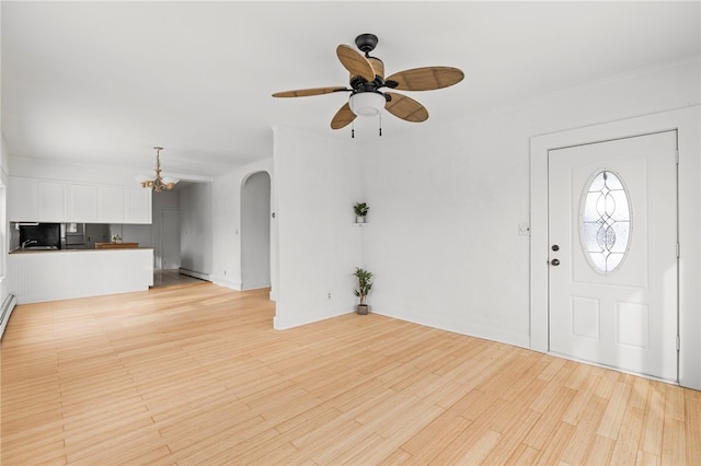 foyer with a baseboard radiator, light wood-type flooring, and ceiling fan with notable chandelier