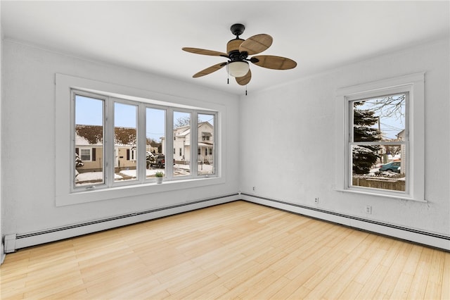 unfurnished room featuring ceiling fan, plenty of natural light, and a baseboard radiator