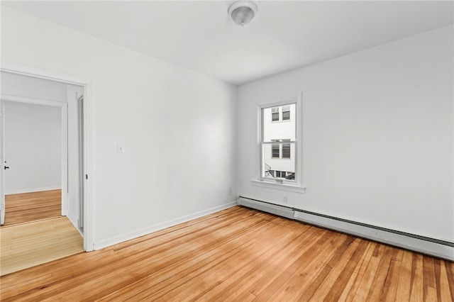 unfurnished room featuring light hardwood / wood-style floors and baseboard heating