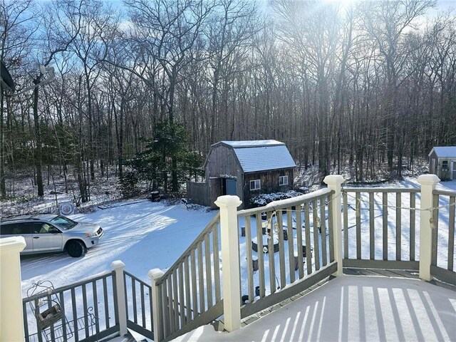 snow covered deck featuring an outdoor structure