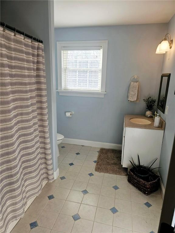 bathroom featuring toilet, vanity, and tile patterned flooring