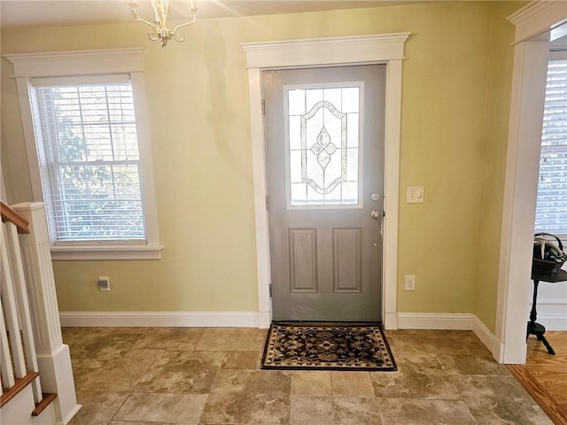 foyer featuring a wealth of natural light and a chandelier