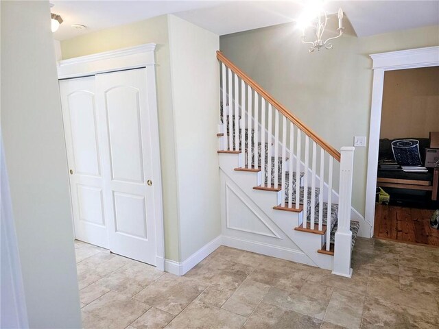 stairs featuring a notable chandelier