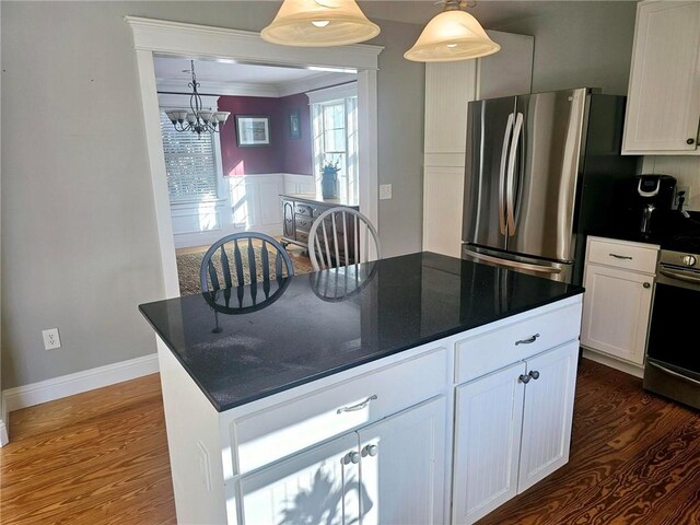 kitchen with a notable chandelier, white cabinets, pendant lighting, stainless steel appliances, and dark hardwood / wood-style floors