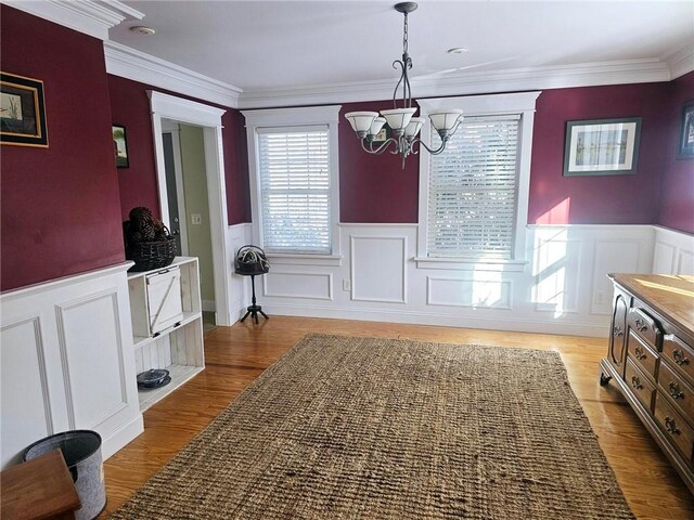 dining room featuring a chandelier, light hardwood / wood-style flooring, and ornamental molding