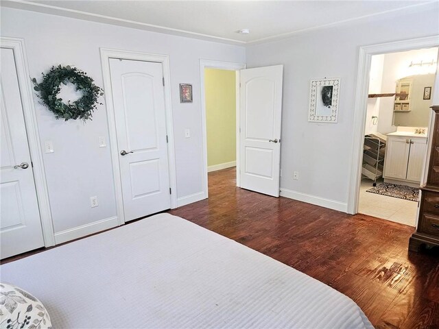 bedroom featuring dark hardwood / wood-style flooring and ensuite bath