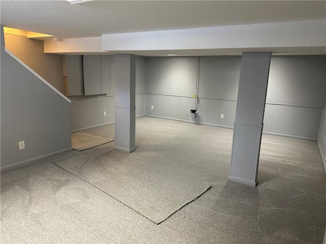 basement featuring carpet flooring and a textured ceiling