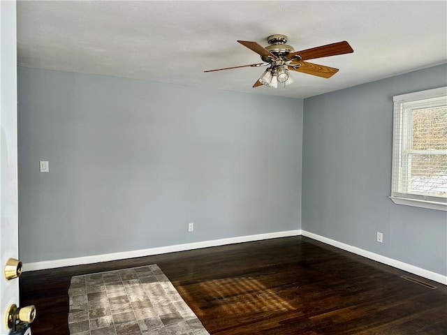 spare room with dark wood-type flooring and ceiling fan