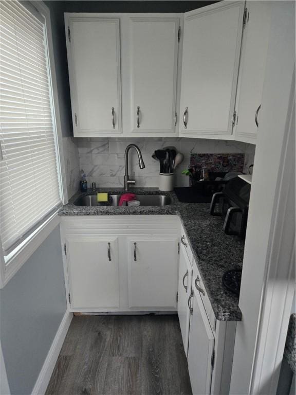 kitchen featuring sink, backsplash, white cabinets, and dark hardwood / wood-style flooring